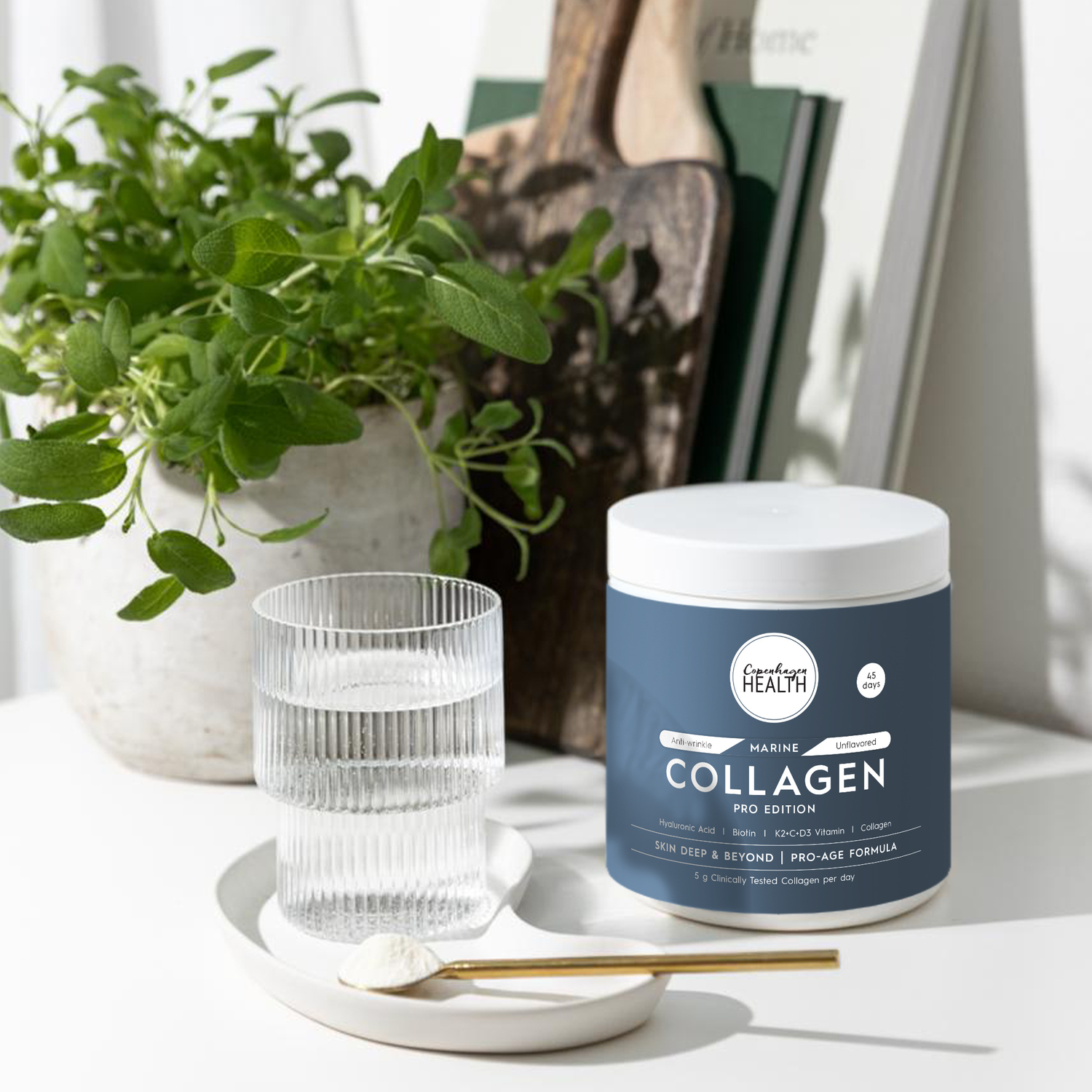 Marine collagen supplement Pro Edition jar with glass of water and plant in a bright setting.